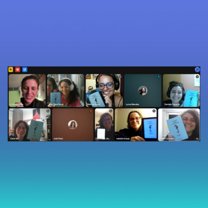 Imagem com fundo em degradê azul e turquesa. Ao centro há uma captura de tela de uma reunião virtual do Clube do Livro d’AzMina.
Diversas participantes aparecem em uma grade de videoconferência. Muitas delas sorriem e exibem para a câmera exemplares de um livro de capa azul-clara com a ilustração de um cavalo-marinho na capa. Algumas utilizam fones de ouvido e óculos. Outras participam por foto de perfil ou com a câmera desligada.
Os ambientes são predominantemente domésticos, com iluminação quente e acolhedora. A imagem comunica um momento de conversa, troca de impressões sobre a leitura e fortalecimento da comunidade de leitoras.